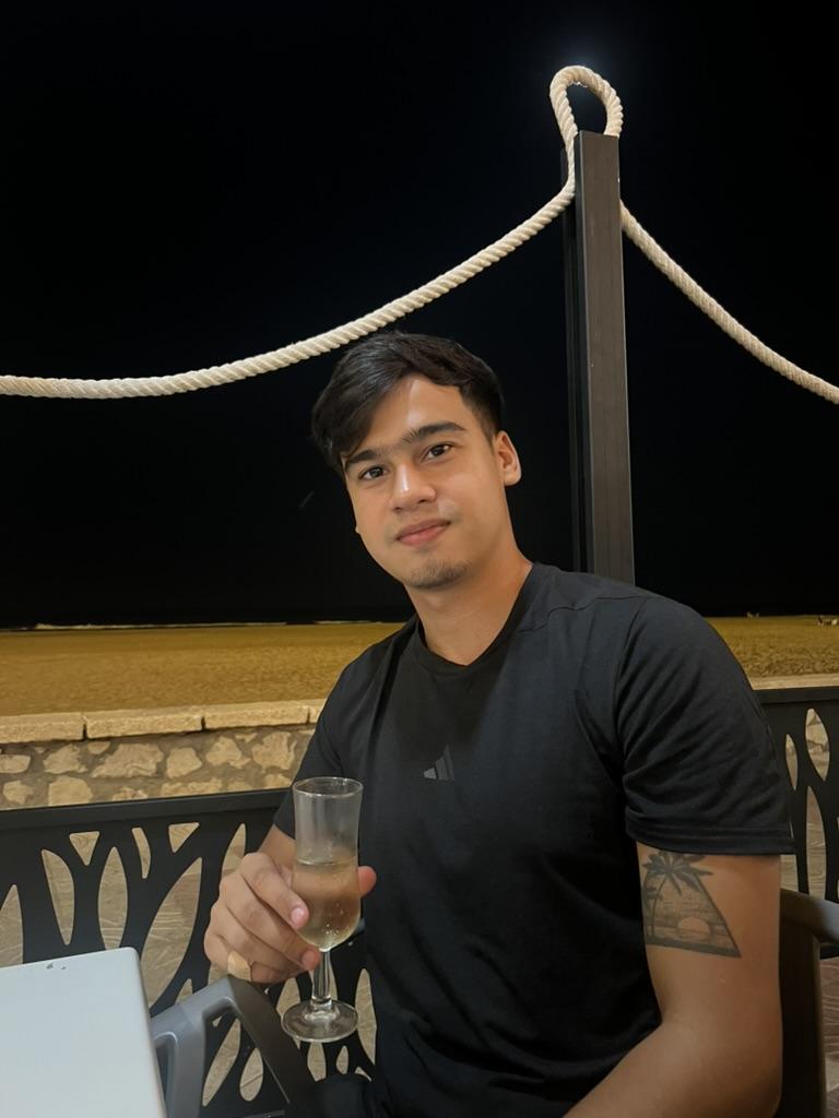 Franco Rossi en la terraza de un restaurante junto al mar por la noche.